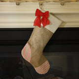Christmas stocking with burlap boot, light beige cotton cuff with attached red burlap bow, and red ticking heel & toe patches.